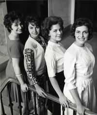 Four students posing on staircase
