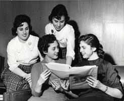 Students looking at Yeshiva University material in binder