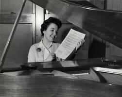 Student Barbara Gross (composer of SCW alma mater) seated at piano