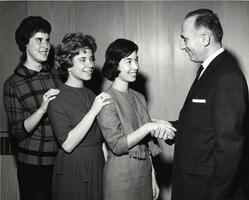 Students shake hands with unidentified man at Purim event