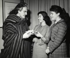 Students present hamantaschen to costumed man on Purim