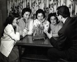 Students at table with menorah listening to a talk