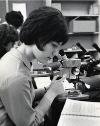 Student in lab using microscope